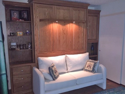 Traditional Murphy Wall Bed with Sliding Library Bookcase and Side Cabinets shown in Golden Stain on Oak