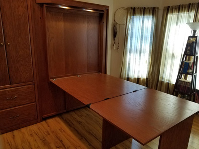 Savona Murphy Wall Bed and Side Wardrobe Cabinet with Custom Double Attached Desk / Desk with Lighted Leg at Top shown in Cinnamon on Oak