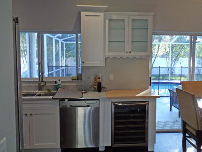 Home Bar with Shaker Custom Cabinets with Butcherblock Countertop and Wine Cooler shown in Solid Pure White on Maple