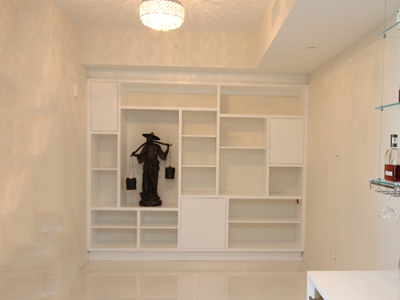 Custom Built-In Modern Wall Unit Cabinetry with Fixed and Adjustable Shelve shown in Solid Bright White on Maple with Black Bar 7” Pulls