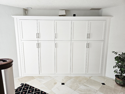 Custom Shaker Built-In Storage Cabinetry with Adjustable Shelves, 3” Crown Molding, Flat Trim and 3” Flat Base Molding shown in Solid Bright White on Maple with Nickel Bar Pulls