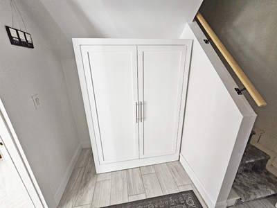 Custom Free-Standing Storage / Coat Cabinet. Shown here is 2 Full-Size Shaker Panel Doors, 1 Fixed Shelf Above Chrome Clothes Rod in Solid Bright White on Maple with Nickel Bar Handles