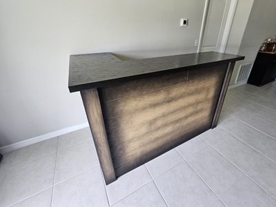 Custom L Shape Rustic Plank Bar with Solid Black Countertop Shown in Custom Dusting Black on Solid Red Oak