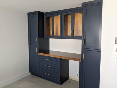Custom Dry Bar Shaker Cabinetry with Glass Doors, Rollout Drawers and Adjustable Shelves shown in Two Tone Finish Blue and Husk