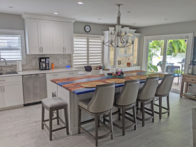 Shaker Kitchen Cabinets with a sleek pantry, refrigerator surround, china cabinet hutch and a desk, all adorned with elegant crown molding and bright white finish on maple. The eye-catching custom two-tone solid wood island is a striking centerpiece.