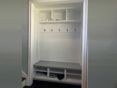 Custom Built-In Shaker Hall Tree Cabinet: Bench Seat above 6 Openings with Adjustable Shelves, 3 Open Top Cubbies, and Simulated Shiplap Backing Mudroom Cabinet with 5 Hooks shown in Solid Bright White on Maple