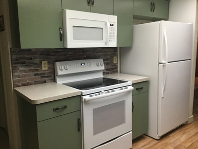 Custom Kitchen Cabinets with Modern Flat Door shown in custom green Nesika Bay and Upgraded Premium Pulls