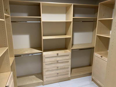 Custom Built-In Wardrobe Closets with Drawers, Rods, Hamper, Mirror, Shoe Storage shown in Natural on Maple