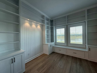 Built-In Floor to Ceiling Shaker Cabinets and Open Shelves with Simulated Shiplap Backing shown in Bright White on Maple