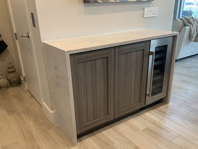 Custom Shaker Dry Bar Cabinet and Wine Fridge with Laminate Push-to-Open Doors, Roll-Out Drawer and Quartz Countertop shown in Wilson Art Portico Teak