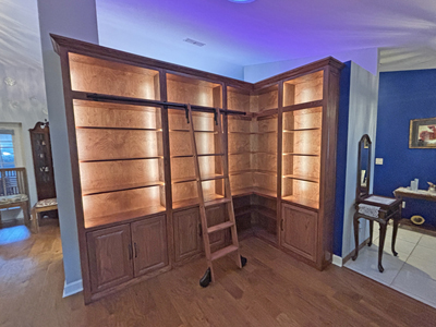 Custom Traditional Bookcase with Sliding Ladder and LED Lighting shown in Mahogany on Oak