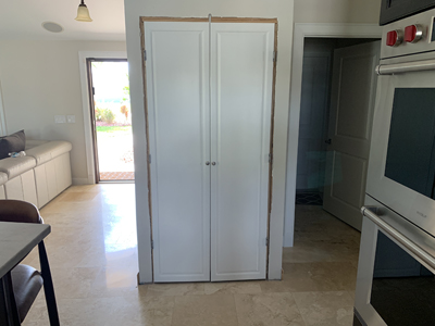 Custom Kitchen Pantry with Traditional Raised Panel Doors shown in Bright White and Natural on Maple with Nickel Knobs