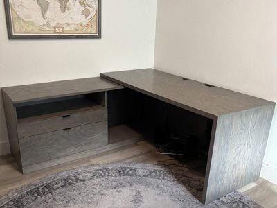 Custom Euro Open L-Shape Desk with Panel Legs and File Cabinet shown in Soft Gray on Oak
