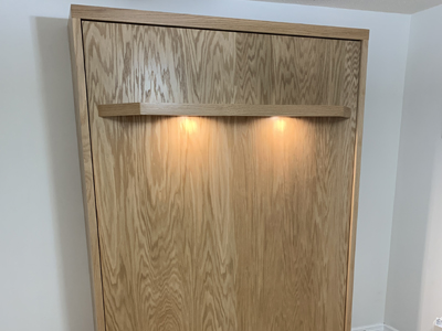 Siena Queen Vertical Murphy Wall Bed with Flat Face, Center Seam and Lighted Shelf Leg shown in Natural Stain on Oak