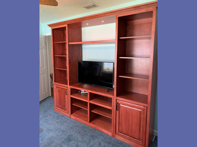 Custom Traditional Entertainment Center with Open Shelves, Raised Panel Doors, Center Cleated Shelf and Light Bridge shown in Custom Red Head Stain on Maple