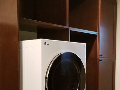 Custom Built-In Shaker Laundry Cabinets with 6” Crown shown in Mahogany on Maple